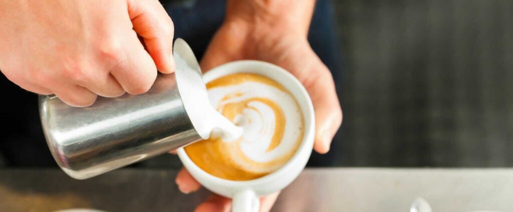 barista che schiuma il cappuccino